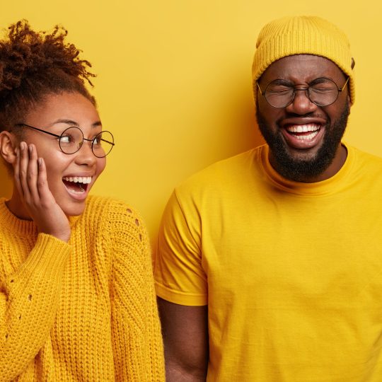 Two individuals laughing and bonding over shared quirky interests, symbolizing Freak Matching