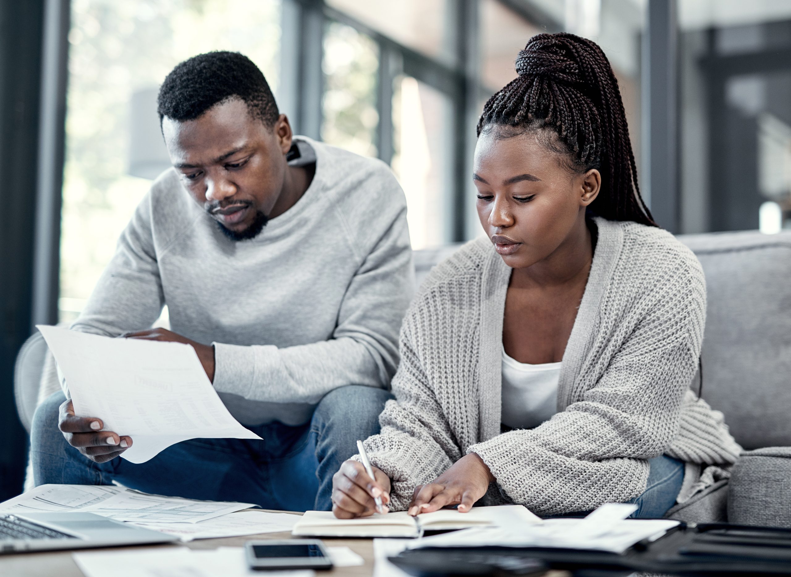 Couple discussing finances and budgeting at a table, looking happy and relieved.