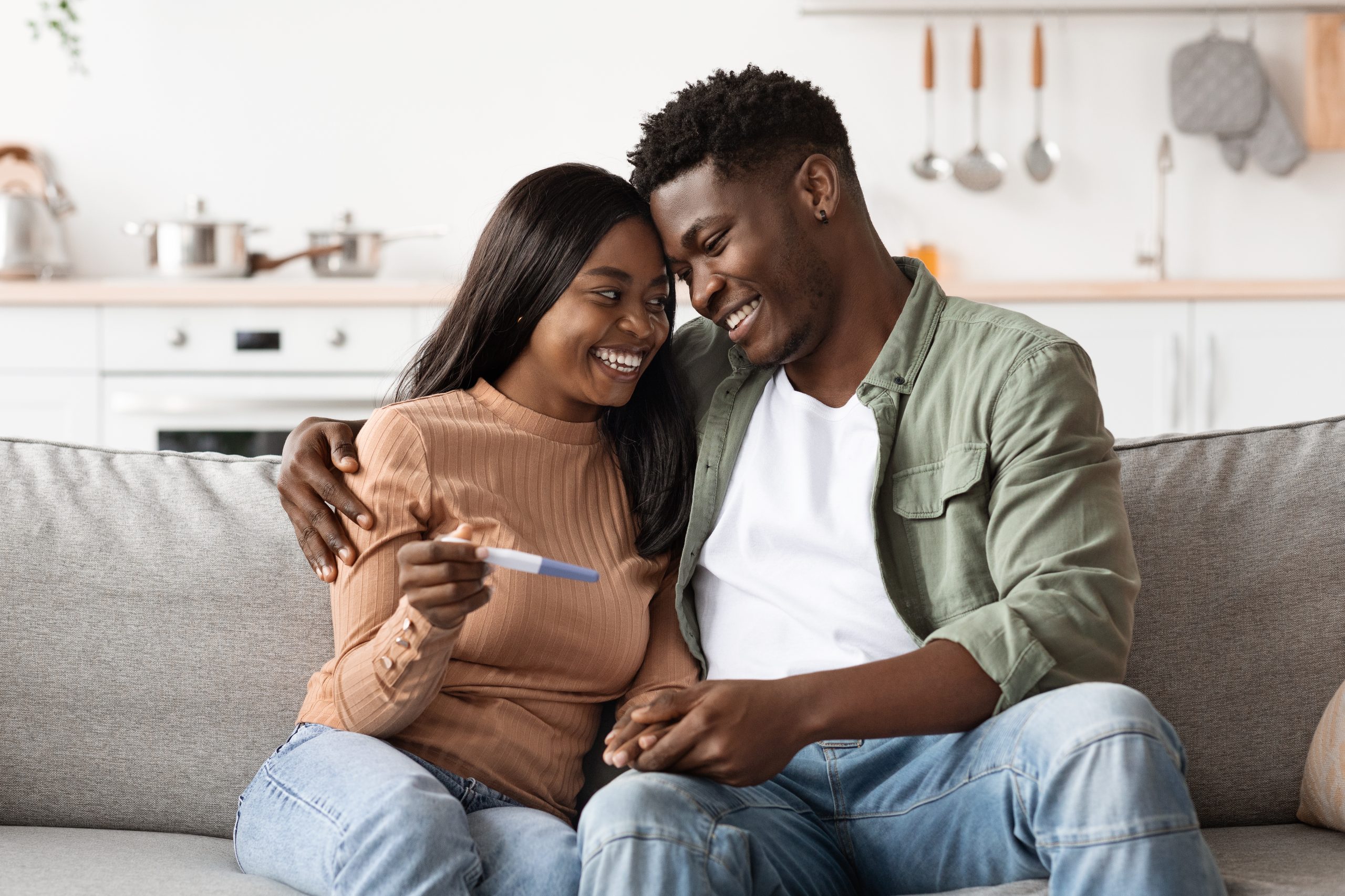 Couple smiling and spending quality time with their baby, representing balance between work, parenthood, and relationship.