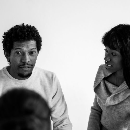 A couple having a serious conversation on the couch, symbolizing emotional honesty and conflict resolution in relationships.