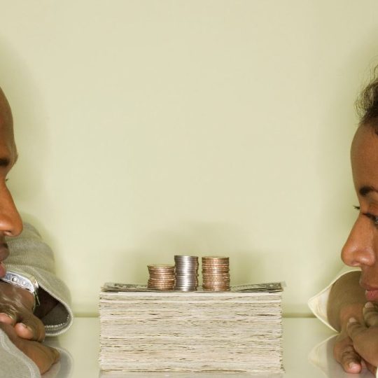 Couple discussing holiday budget plans at home while enjoying hot cocoa