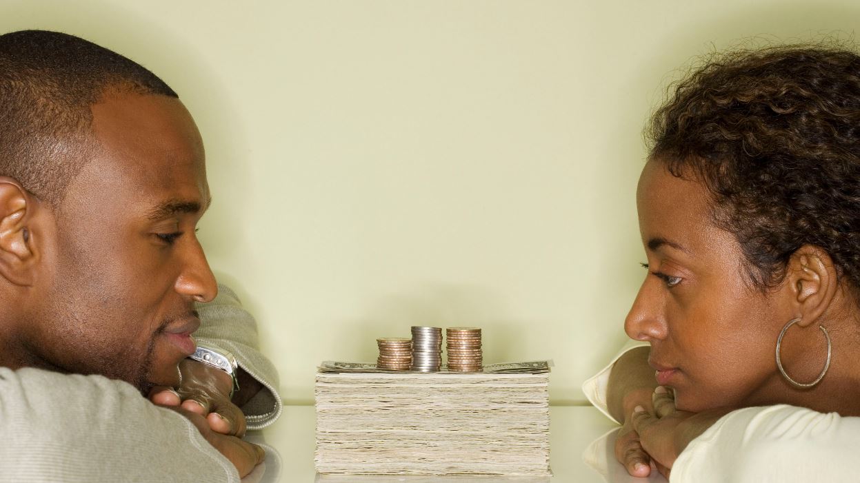 Couple discussing holiday budget plans at home while enjoying hot cocoa